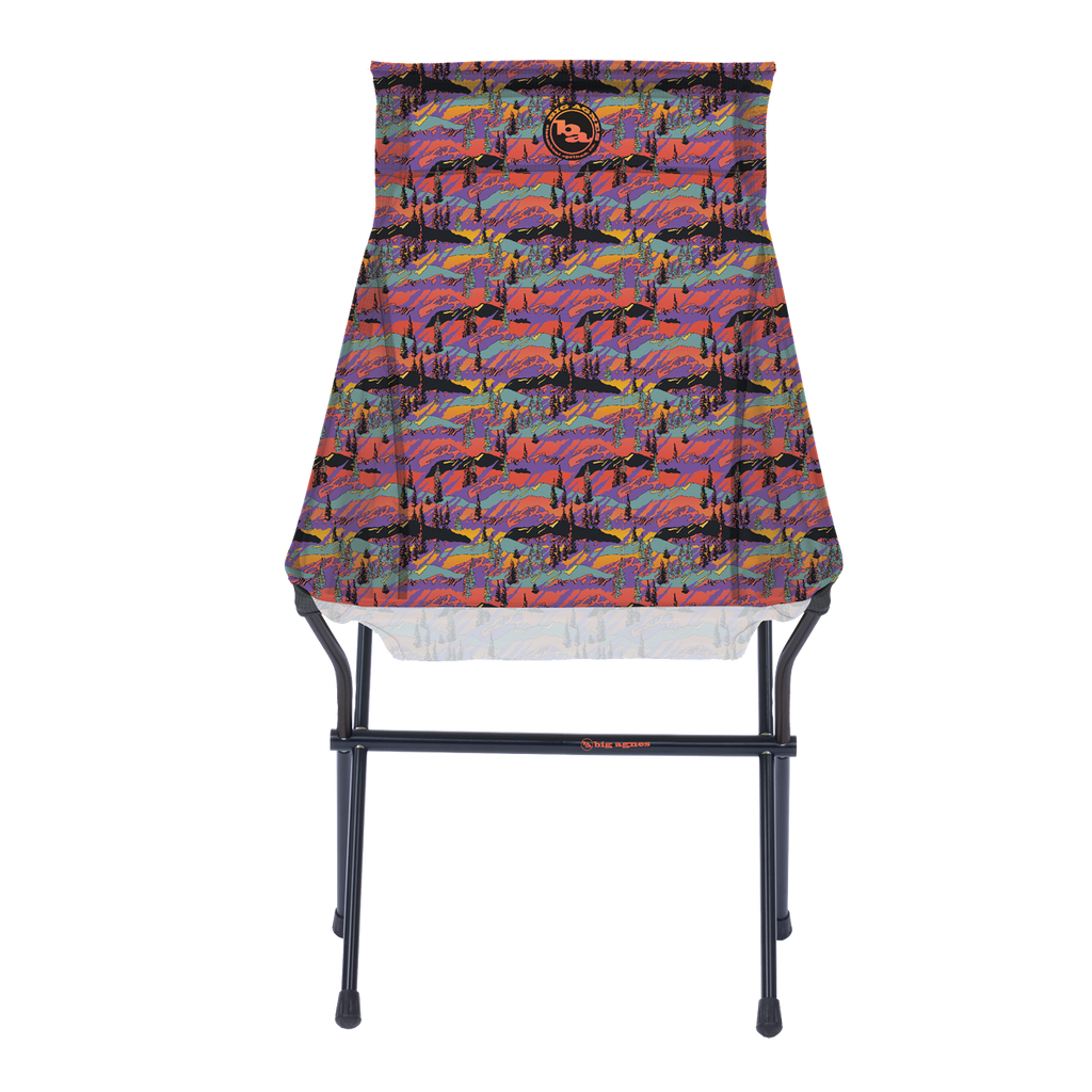 The Big Agnes Big Six Camp Chair - Alpenglow is a lightweight, packable camp chair with a black metal frame and a colorful seat featuring a vibrant abstract mountain landscape in red, purple, blue, and orange.