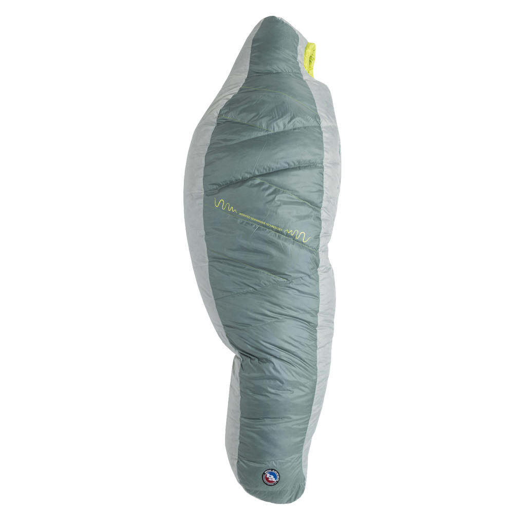 The Big Agnes Returns Sidewinder 0˚, a grey and light green mummy-style sleeping bag, stands upright on a white background, showcasing its tapered shape, quilted design, body mapped insulation, and a small logo near the bottom.