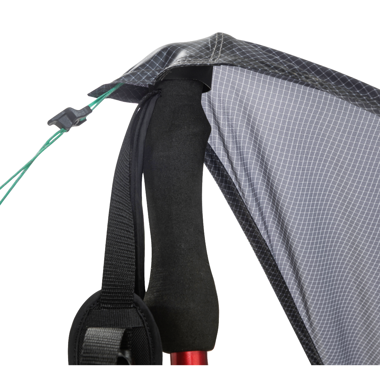 Close-up of the Big Agnes String Ridge VST 1.5, with a trekking pole supporting the tent’s black and gray fabric corner, black strap, and green guyline with a plastic tensioner in this ultralight shelter setup.